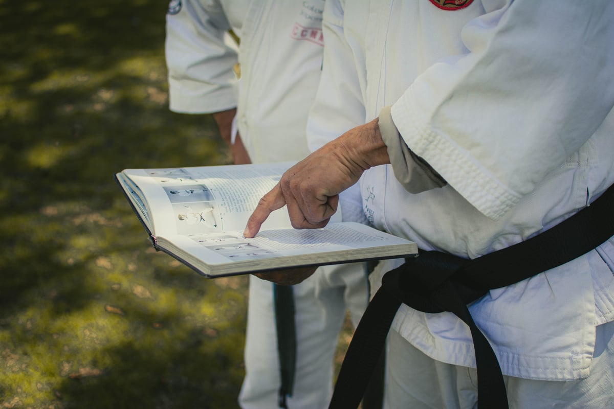 Man in Karategi Holding a Book